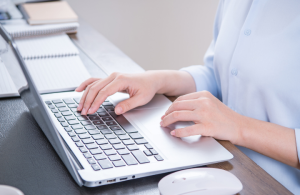 Žena kuca na laptopu za radnim stolom, rad od kuće i vođenje firme putem virtuelne kancelarije