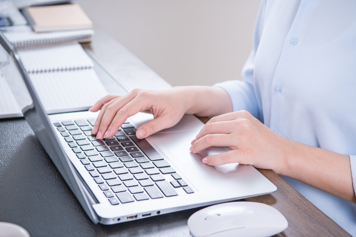 Žena kuca na laptopu za radnim stolom, rad od kuće i vođenje firme putem virtuelne kancelarije